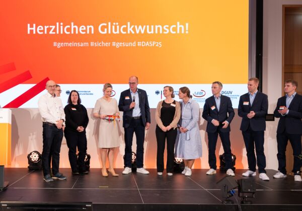 Pressefoto der Vertreter*innen des mit dem Publikumspreis ausgezeichneten Unternehmens und Moderatorin